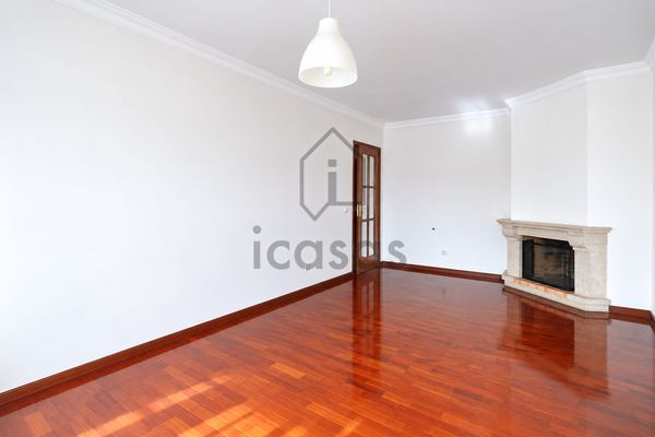 Sala com lareira em pedra, porta envidraçada e soalho de madeira