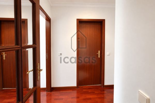 Portas interiores em madeira, uma delas envidraçada, e soalho de madeira